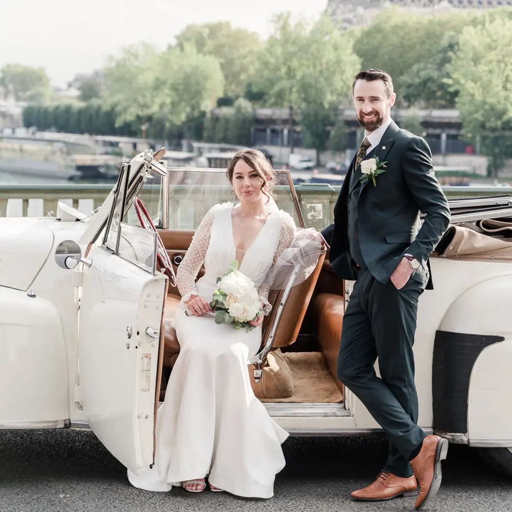 The couple in a vintage car at Bir Hakeim bridge with Eiffel tower as a backfrop