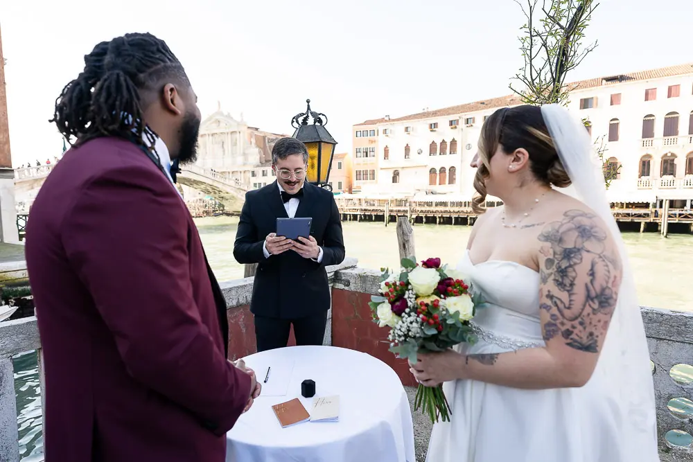 The best man of the groom reads a text during the ceremony, overlooking the grand canal in Venice
