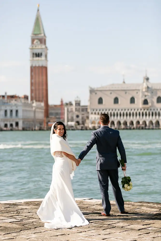 The couple posing after the wedding ceremo,ny with the and San Di georgio as background