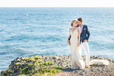 Wonderful couple pose after their vow renewals in front of the mediterranean sea Wonderful couple pose after their vow renewals in front of the mediterranean sea