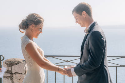 Couple hold hands during their ceremony in Greece with Love Gracefully