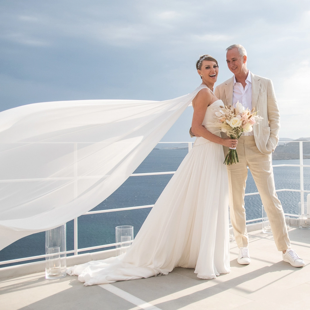 The couple smiling, posing on a boat after their elopement in Sicily