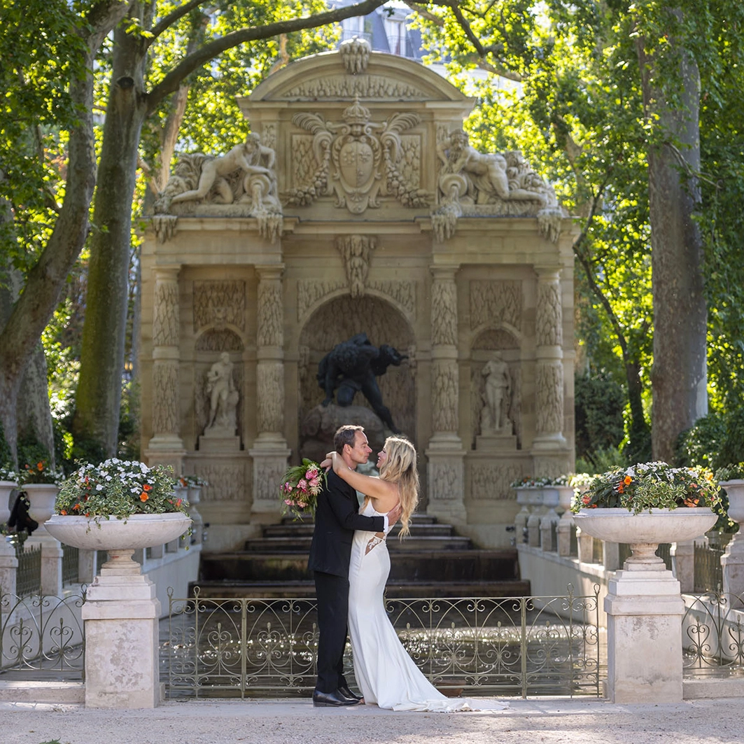 The bride and groom posing in front of the Medicis Fountain in Paris