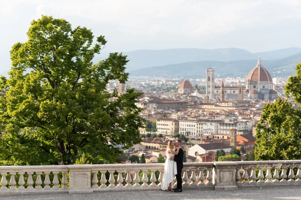 bride and groom embracing each other at a Florence balcony above the city