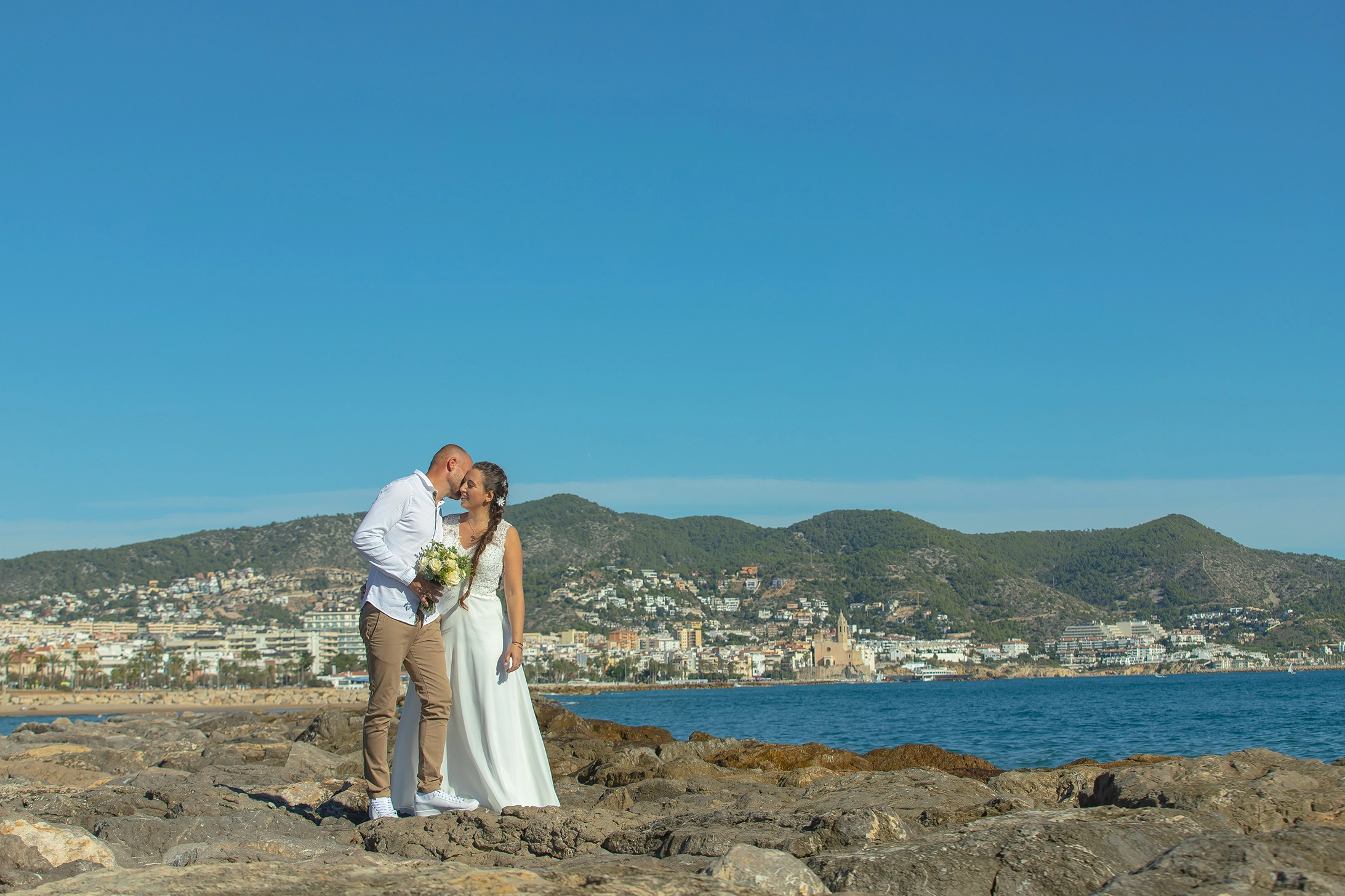 the groom kiss the bride on the beach in Sitges
