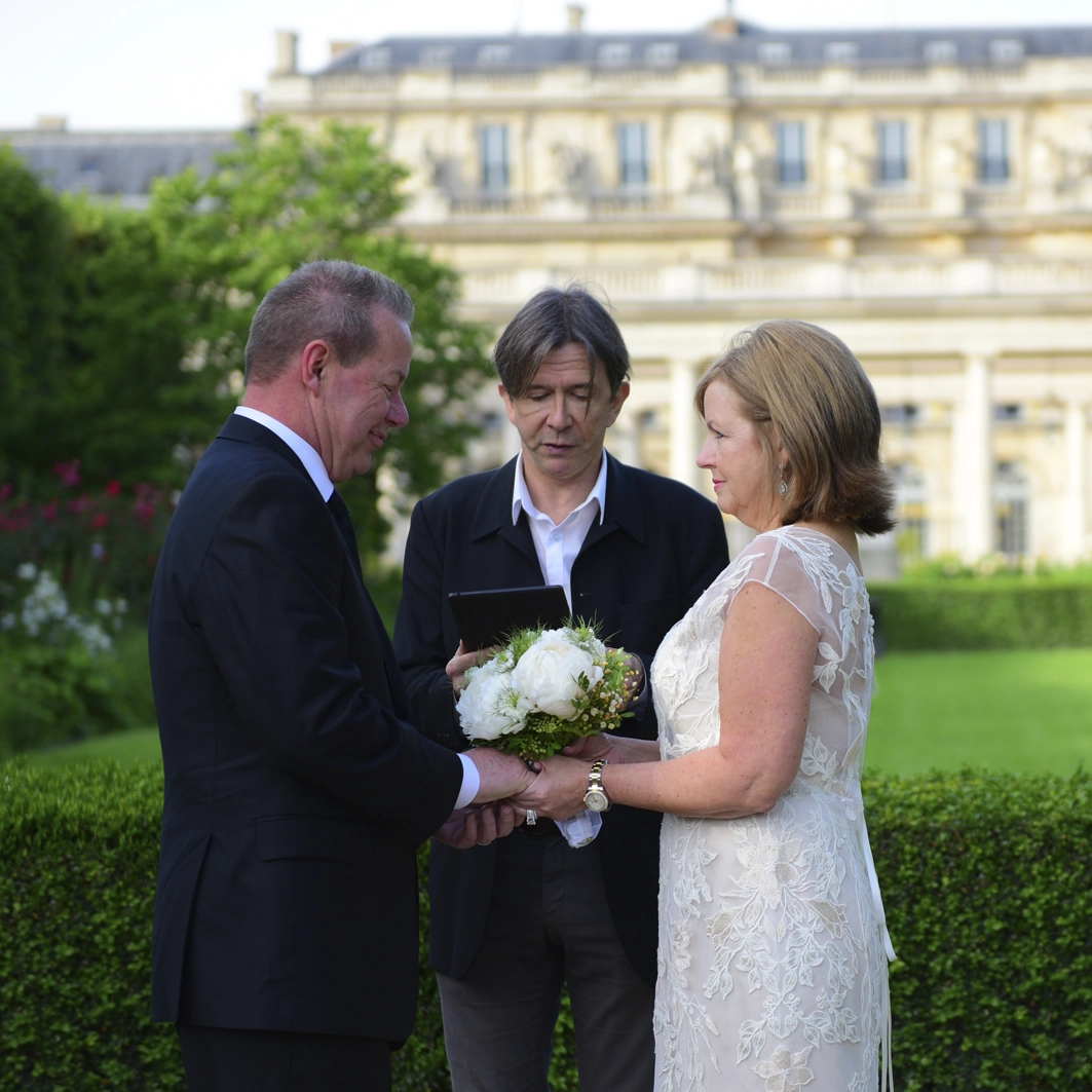 The couple facing each others for their renew of vows 25 years after their wedding, in a private garden