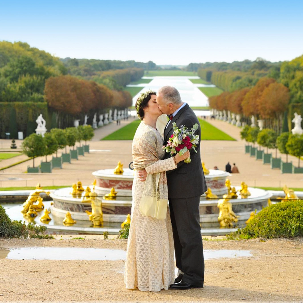 The couple is over the Chateau de versailles garden.
