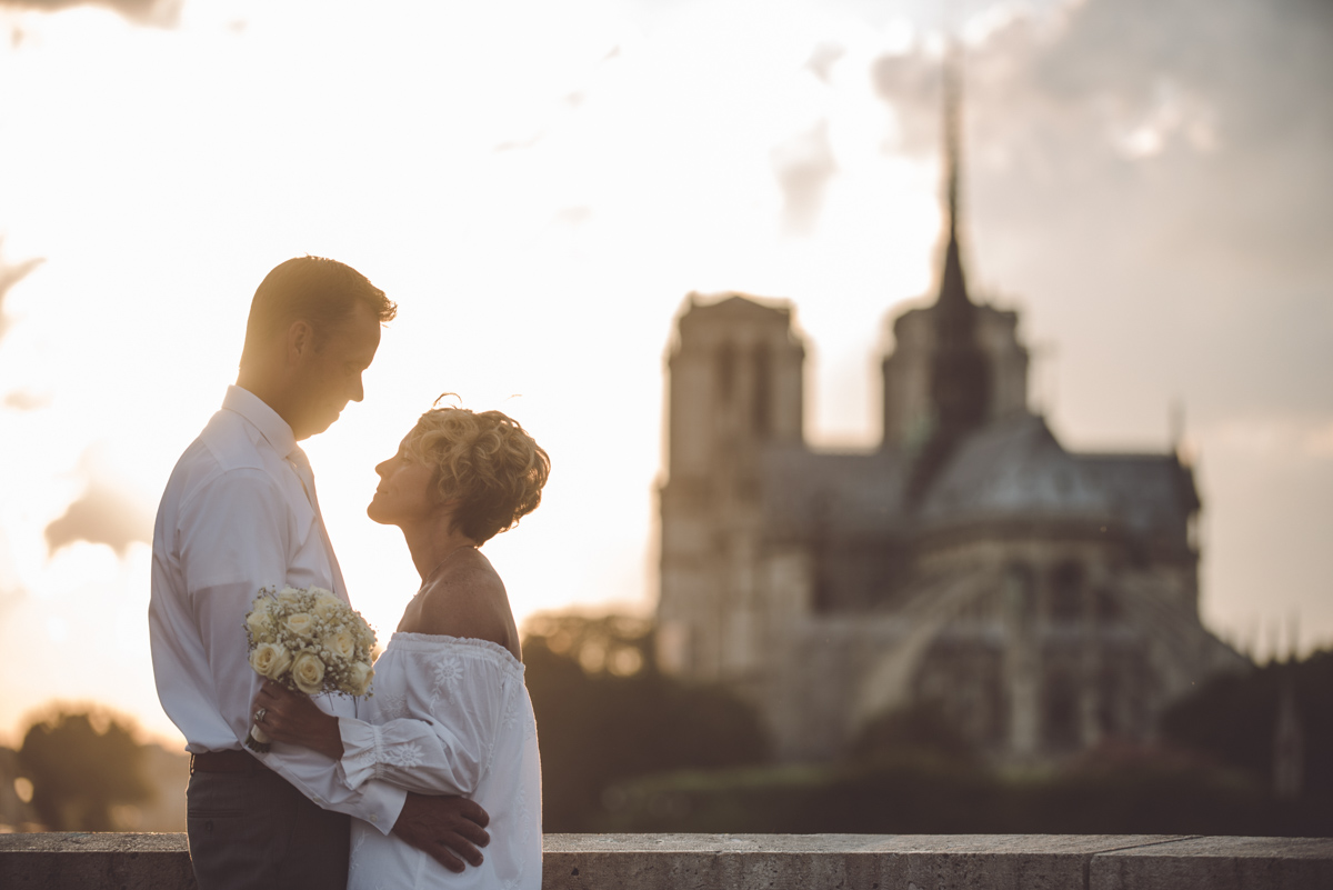 The couple facing each other at the bridge behind Notre Dame