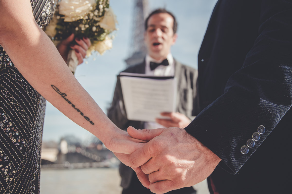 Hand to hand, the bride and groom listen to the celebrant