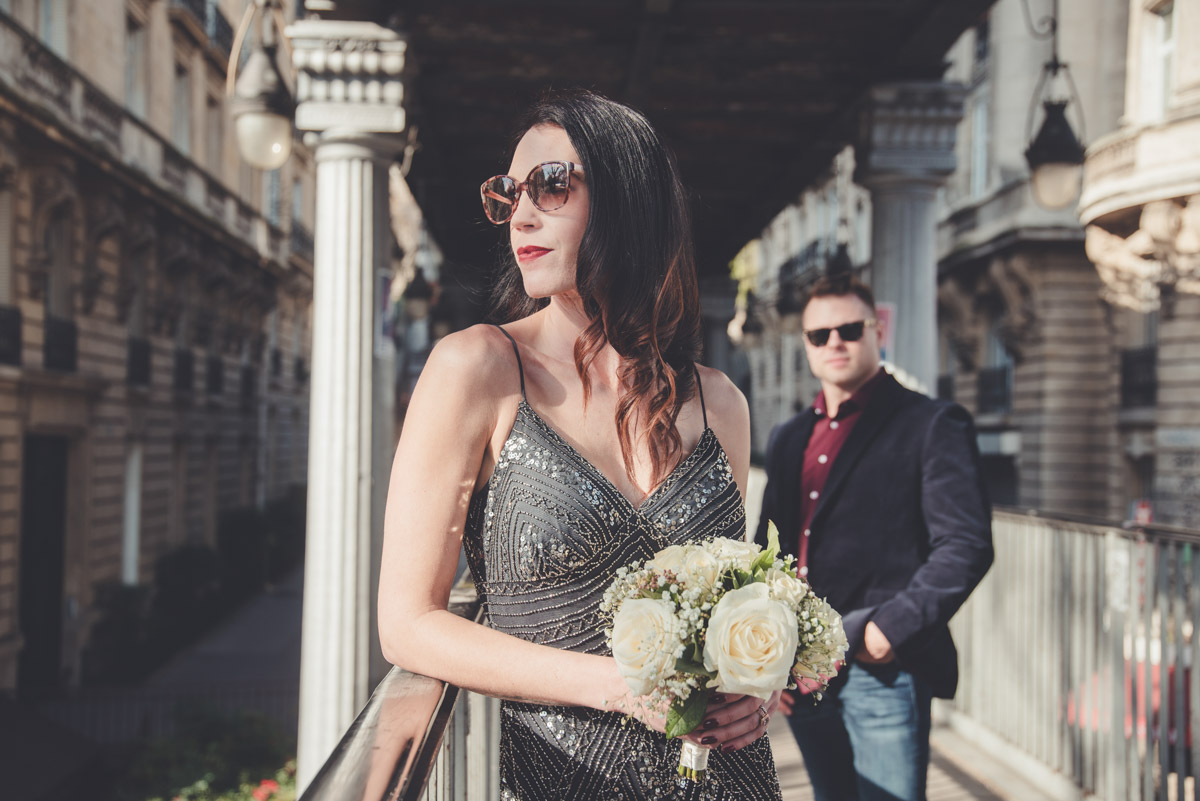 The bride posing with her sunglasses about the street