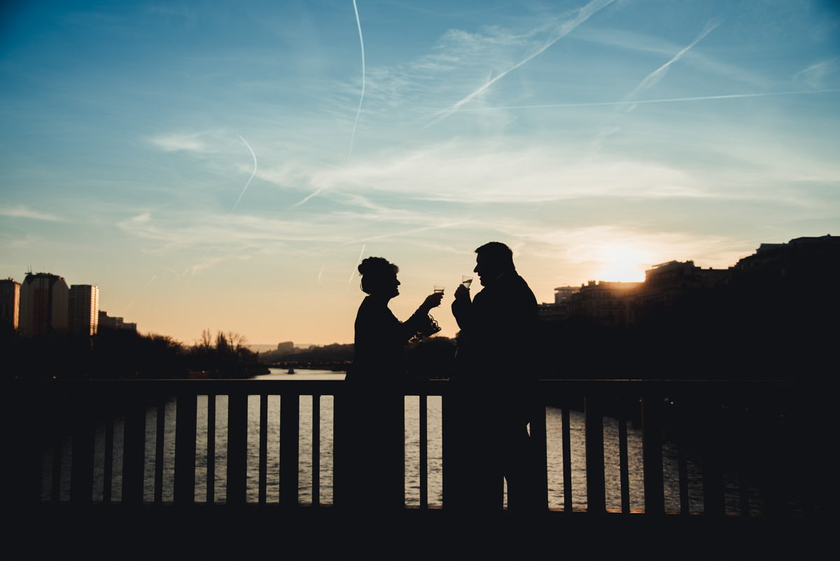 The couple drink a coupe of champagne on the Bir Hakeim bridge