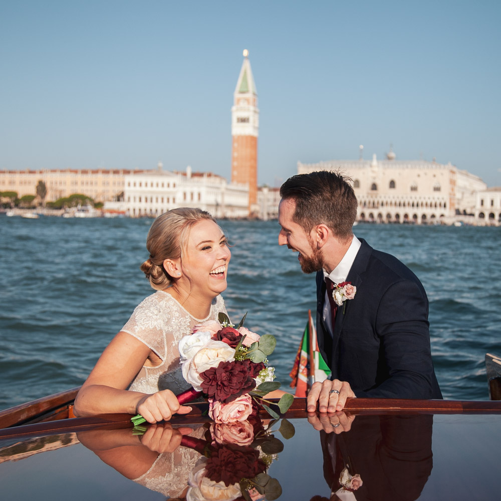 Funny momen tin a boat, the bride is laughing due to her husband telling a joke