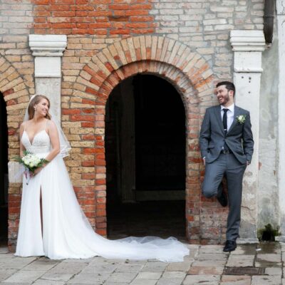 The pose of the couple in a tiny street with cobble stone close to the canal
