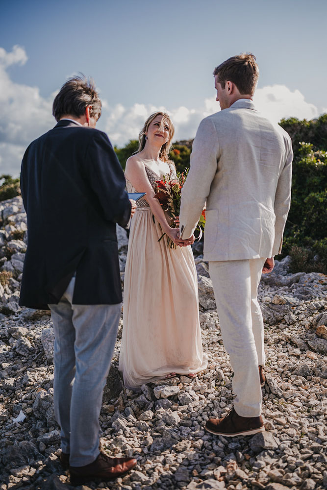The ceremony on the cliff with the bride and groom facing each other