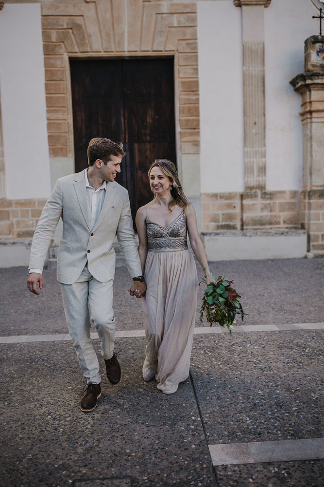 Bride and groom laughing, pretending they come out the city hall