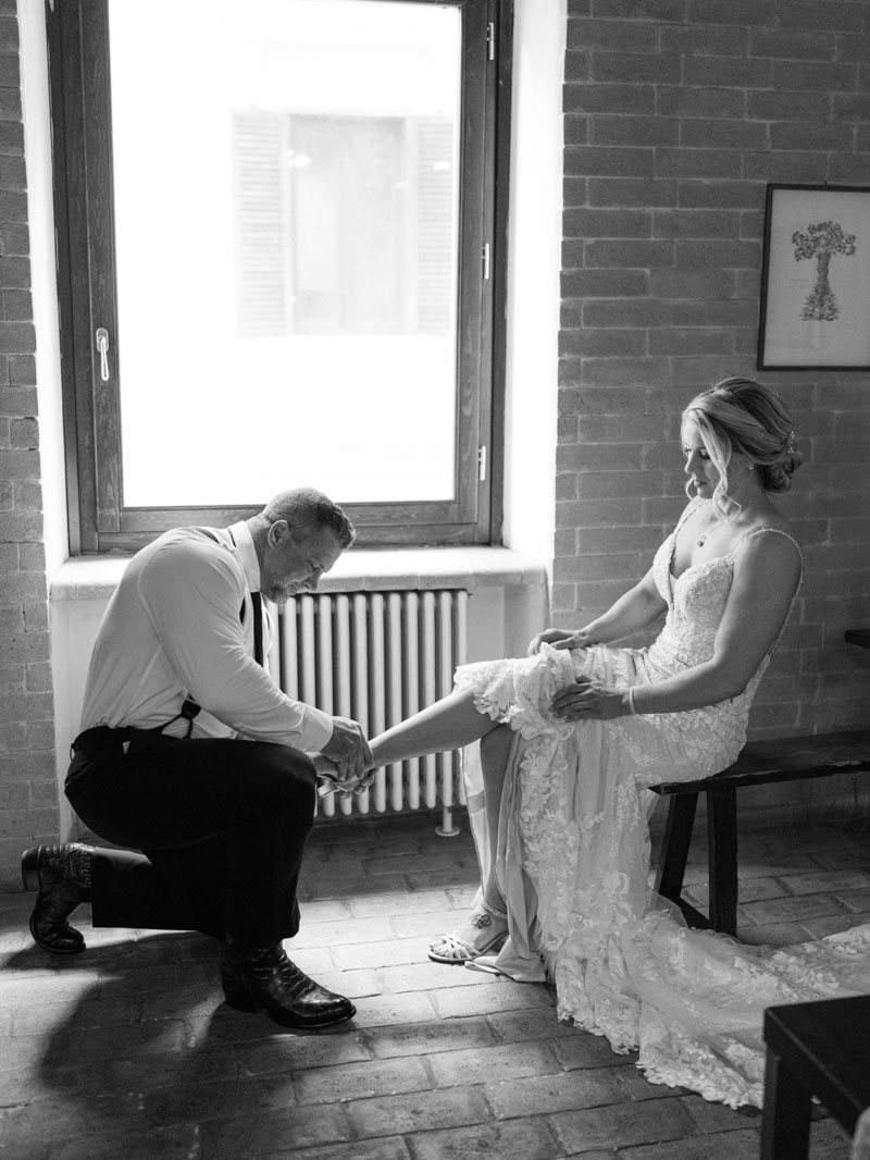 a funny moment, the groom on his knees putting on his wife's shoes