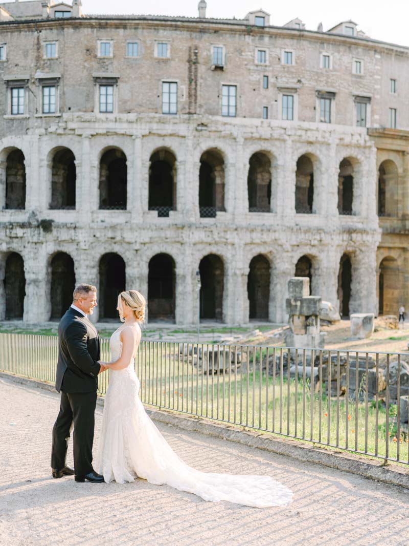 bride and groom posing at Colosseum under sunrise