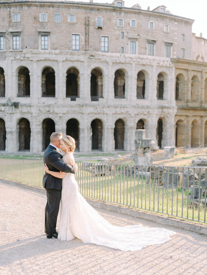 bride and groom kissing at Colosseum under sunrise