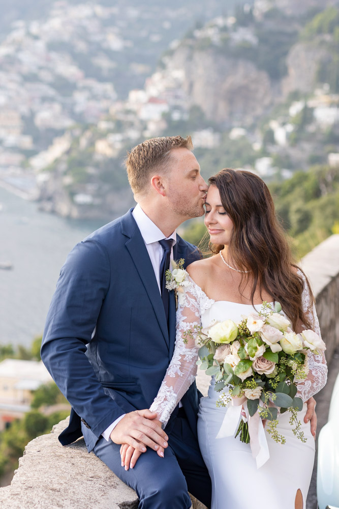 The bride is really happy with a peaceful smile during this forehead kiss