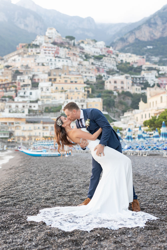 A great kiss photo in front of Positano village on the cliff at Amalfi coast, one of our destinations elopement package in europe