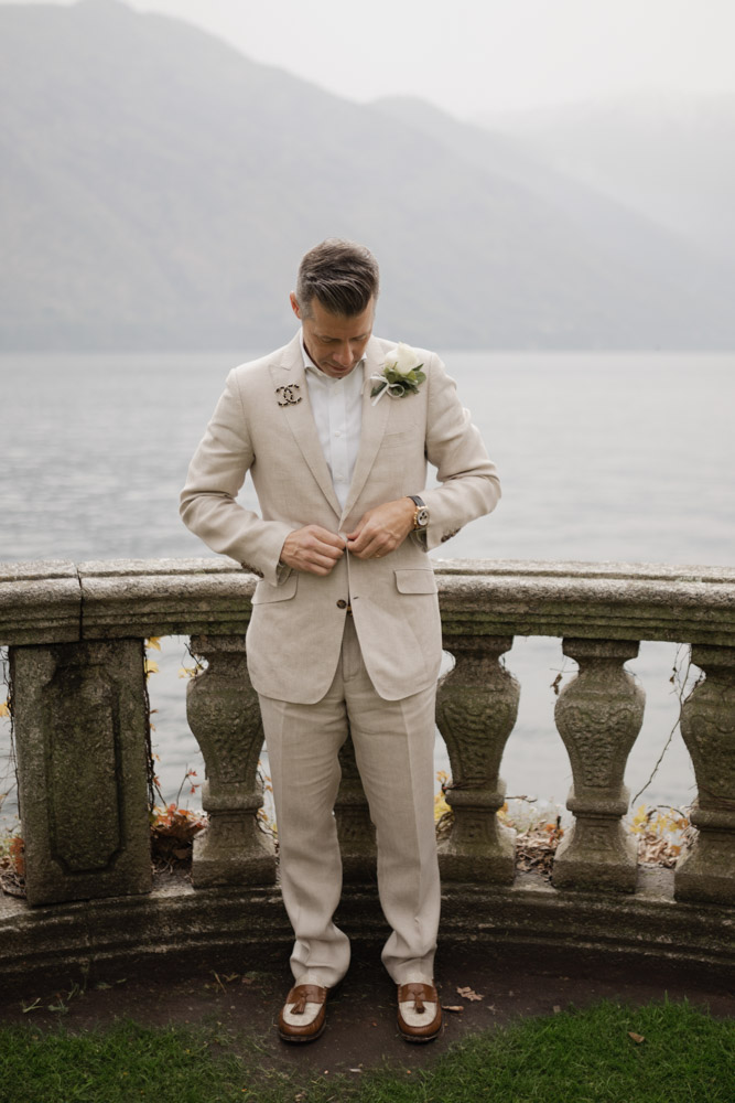 the groom at the balcony over the lake