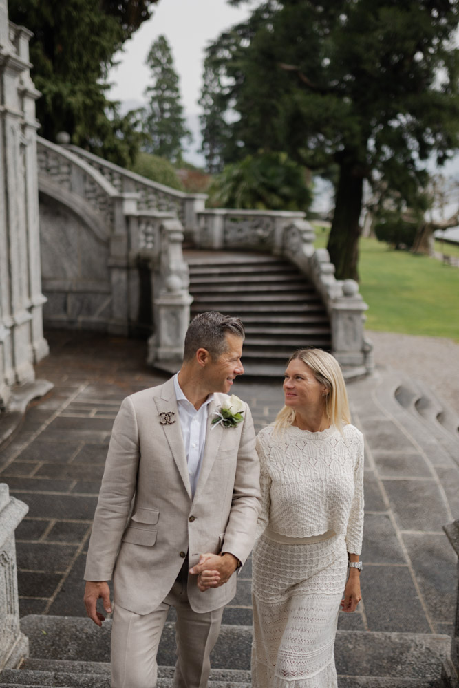 the couple walking down the stairs in the garden of Parco Olivelli, lake como