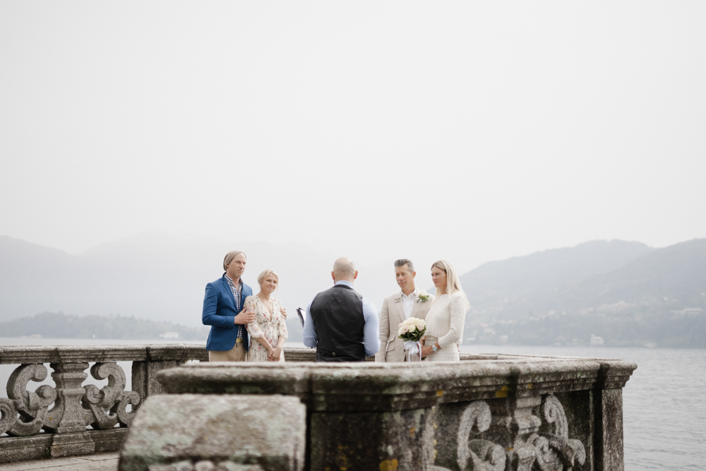 The couple with their friends at the balcony for the ceremony, we see the great view over the lake and the alps in the background
