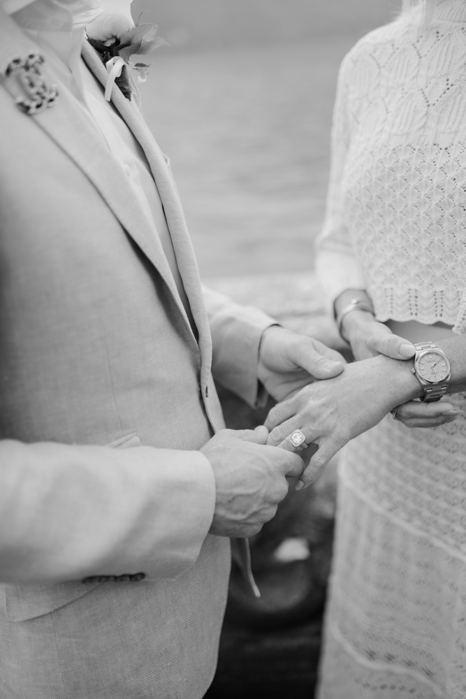 picture in black and white, the hands of couple in close up before the ring exchange