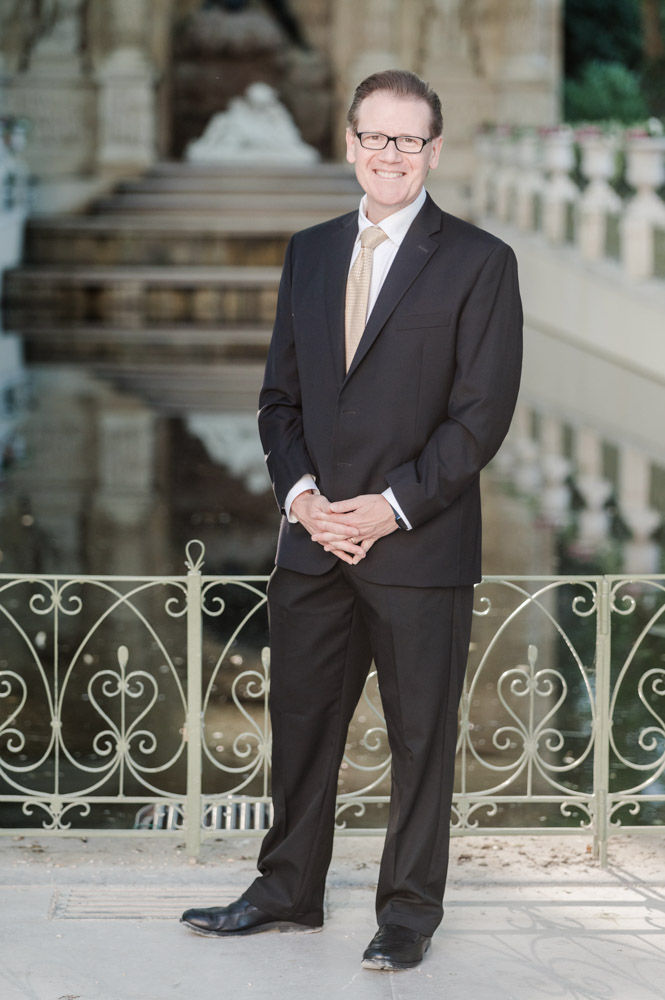 Henri, the elegant groom dressed in a black suit