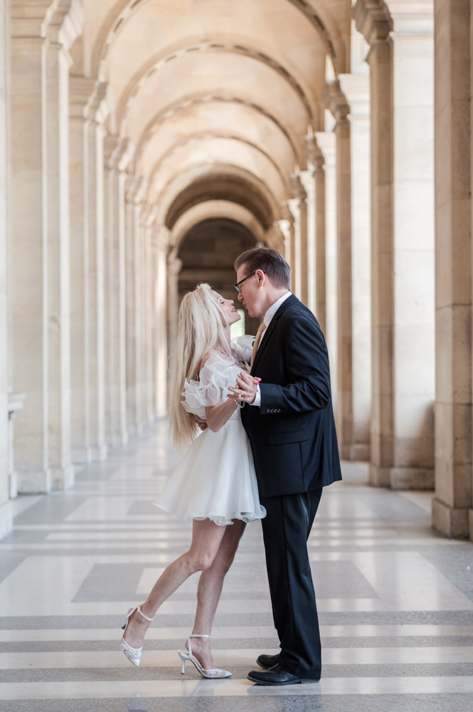 The couple posing in the corridor of the Louvre