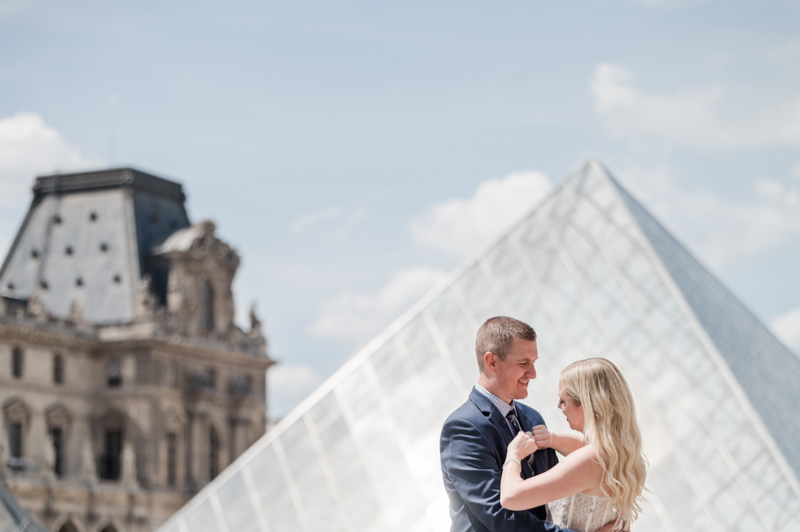 a couple in front of the Louvre Pyramid