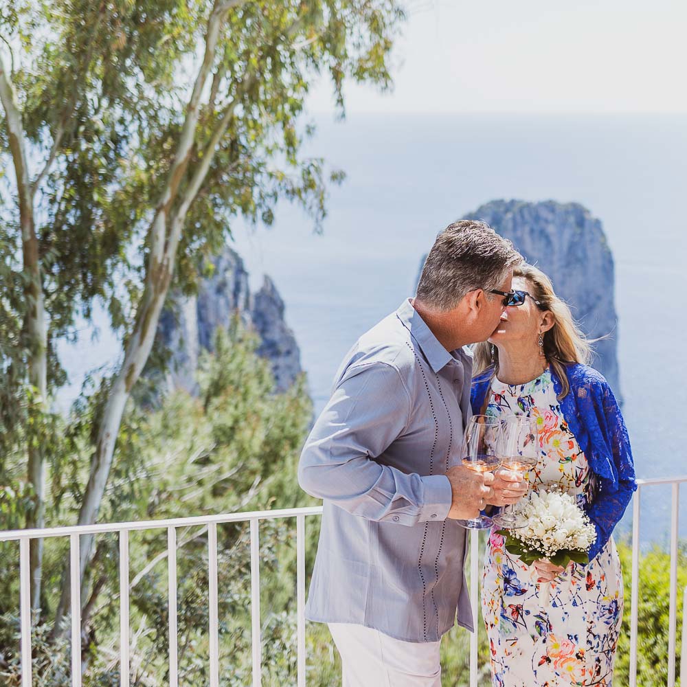 the couple celebrates the vows renewal with a glass of champagne and a kiss