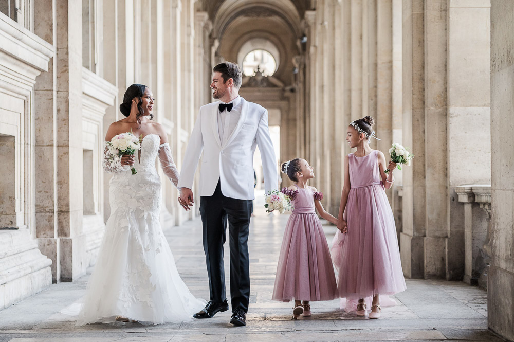 The couple with their 2 pretty young daughters in pink dress at the Louvre alley