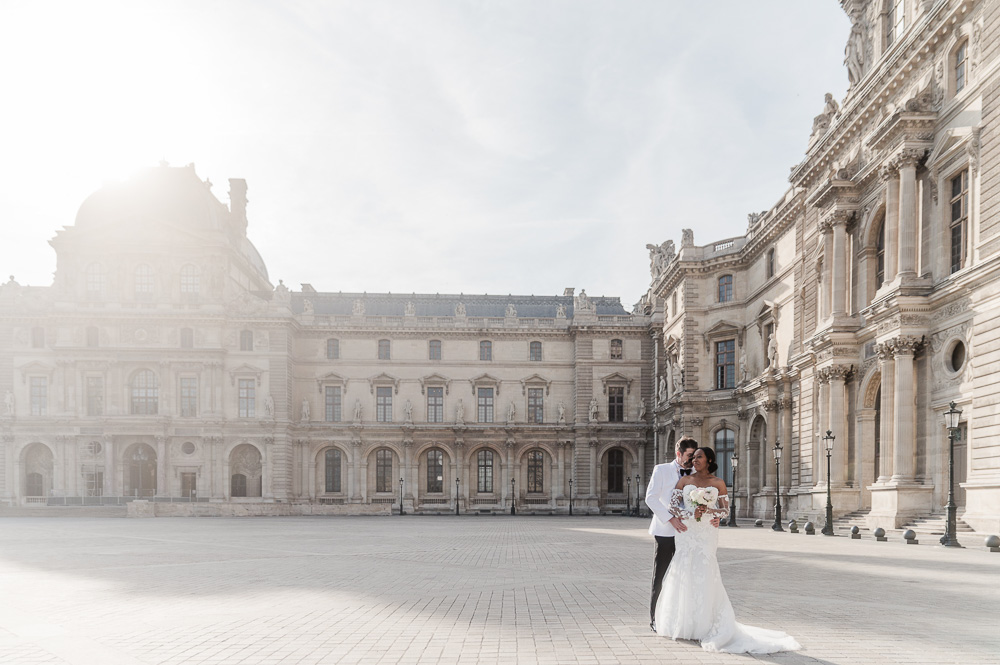 Vows renewal with Family in Paris – 011 The couple posing back lighted in the Louvre court at early morning