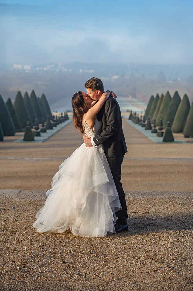 winter wedding in Paris – 0072 The bride and groom kissing with the perspective of the garden in Chateau de Sceaux in winter
