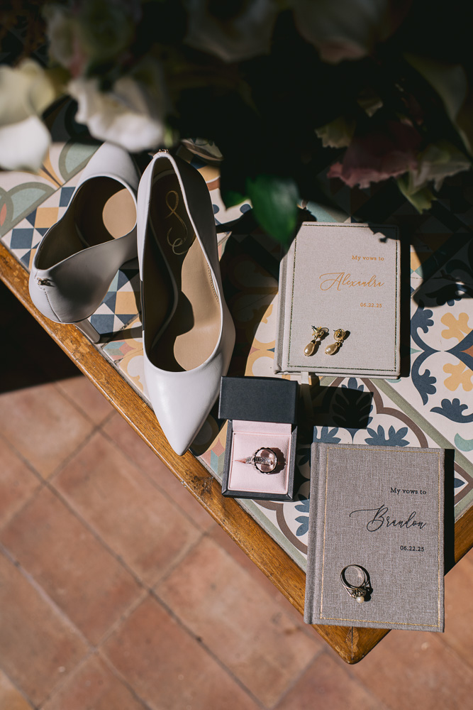 Detail shot with shoes, vows book, rings, flower