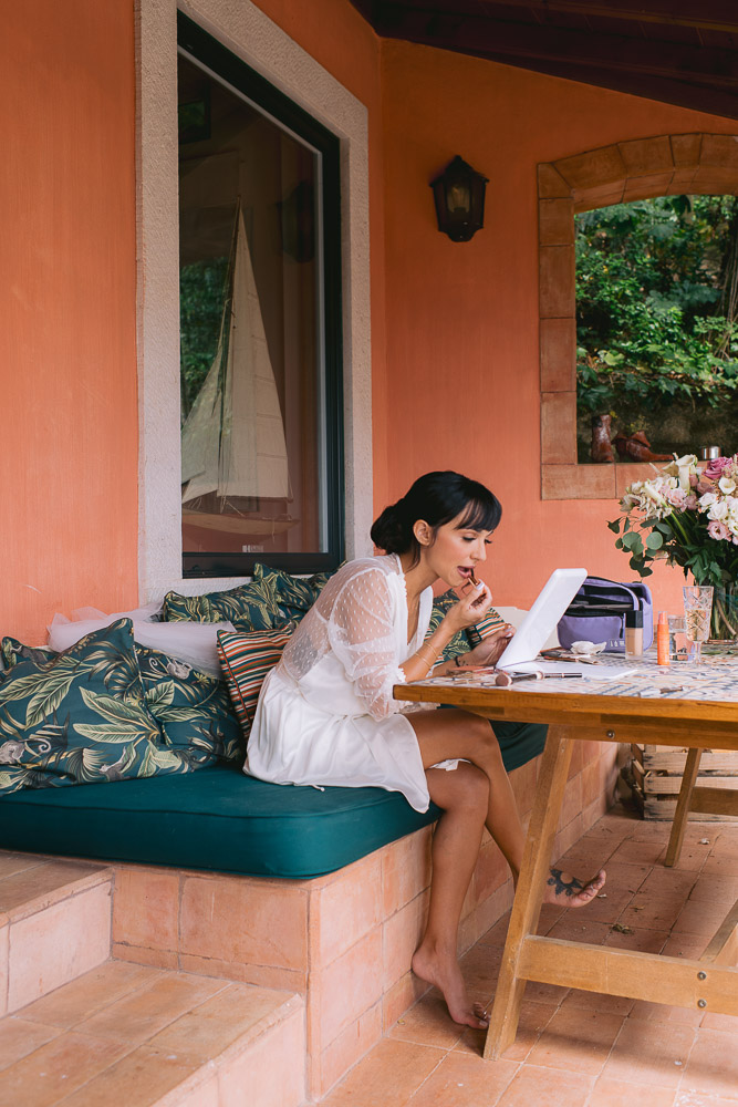 The bride makes her own make up on the terrace of the house