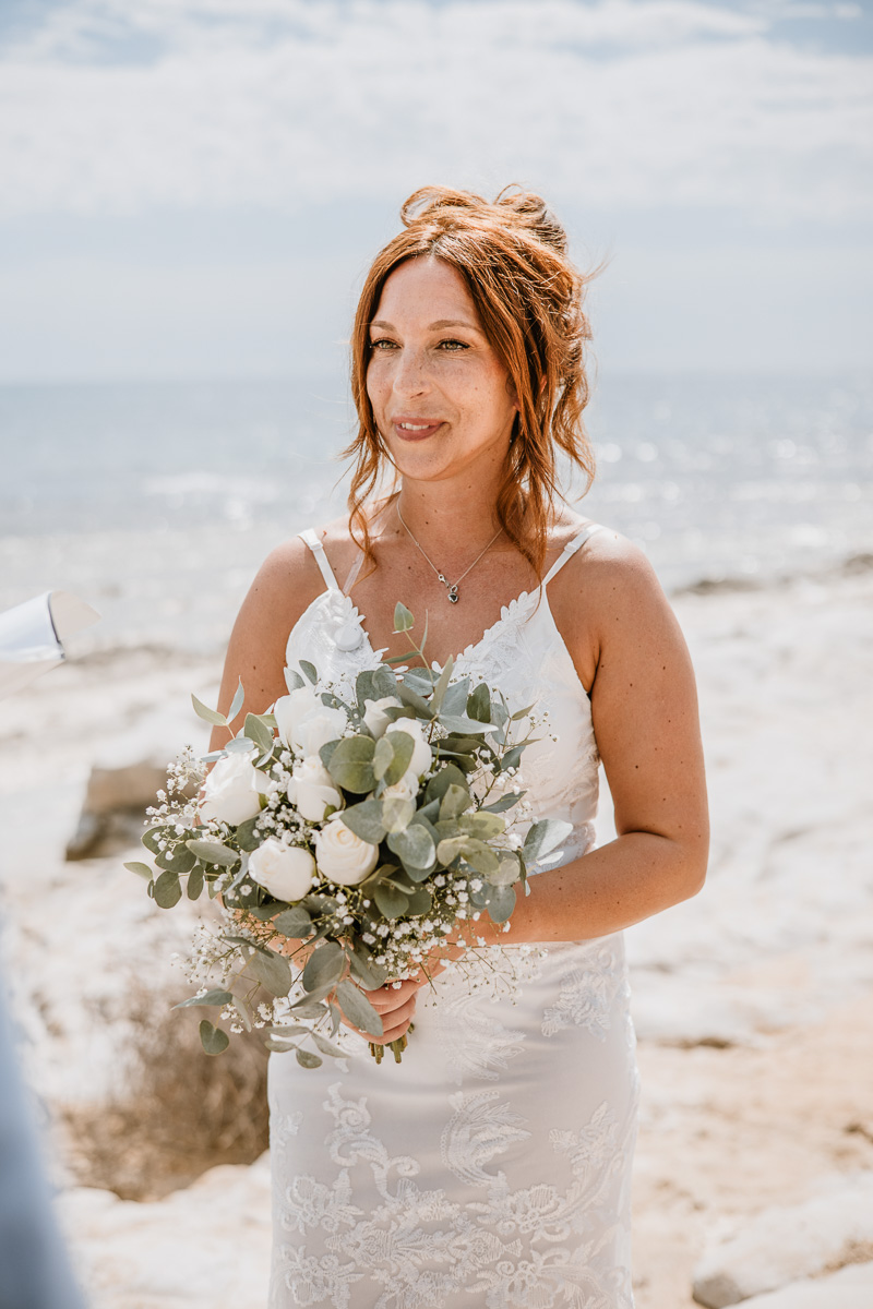 A detail on the bride with her bouquet during the ceremony in Sicily