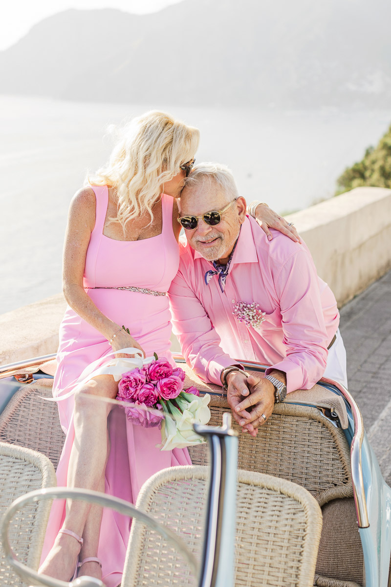 Couple celebrating vow renewal in Positano with a love moment in an Italian car