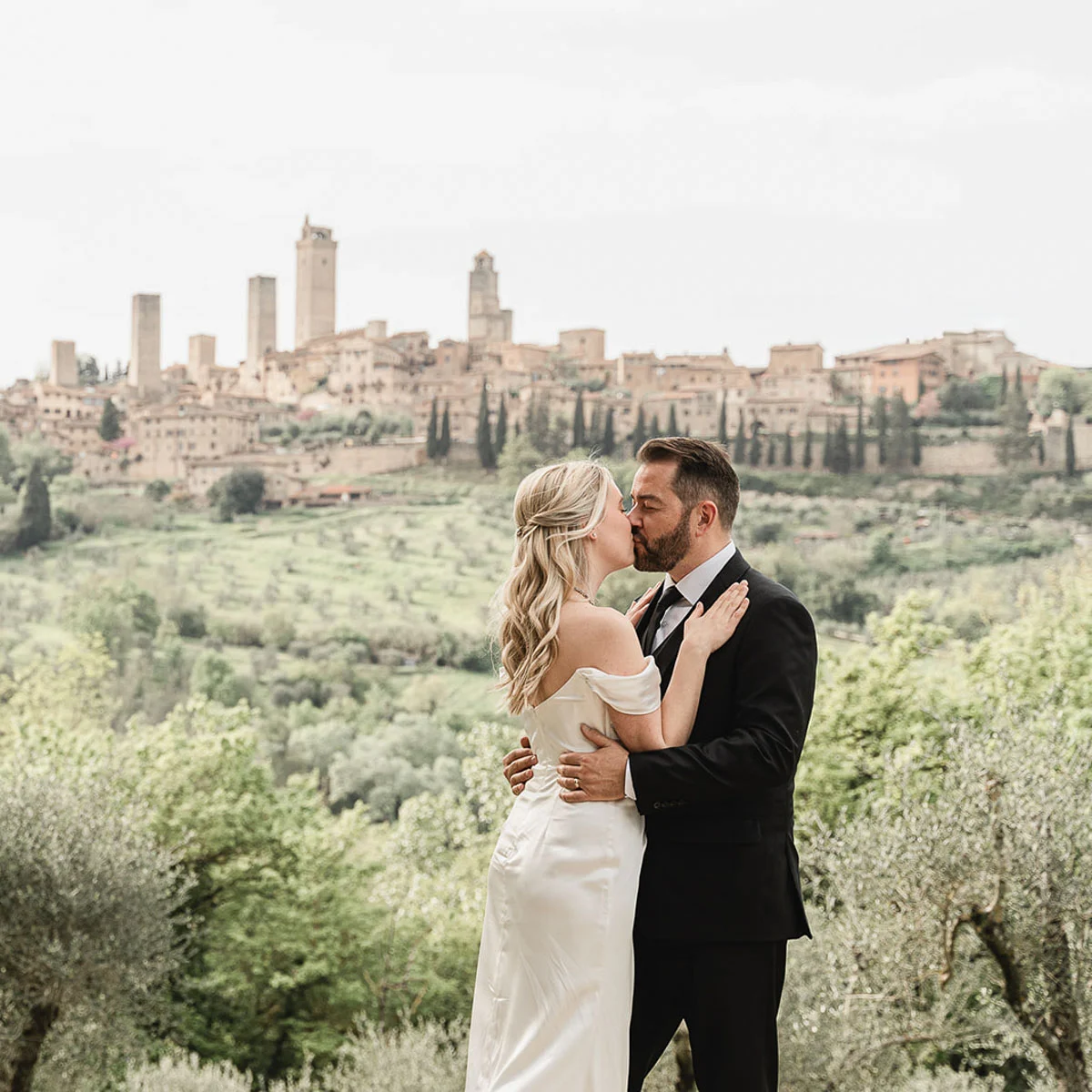Couple kissing in front of San Gimignano medieval towers in Tuscany-Italy