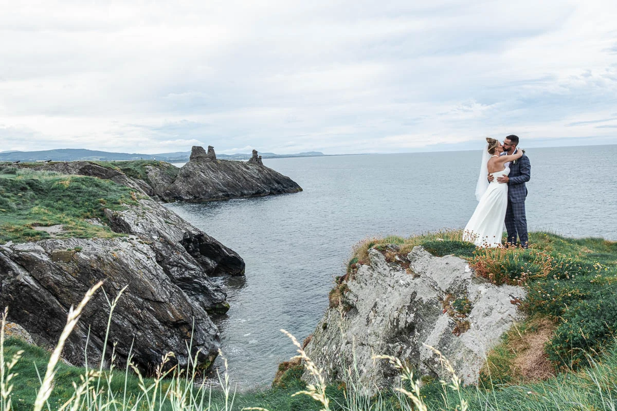 Newlyweds embracing on the cliffs at Black Castle Wicklow Ireland