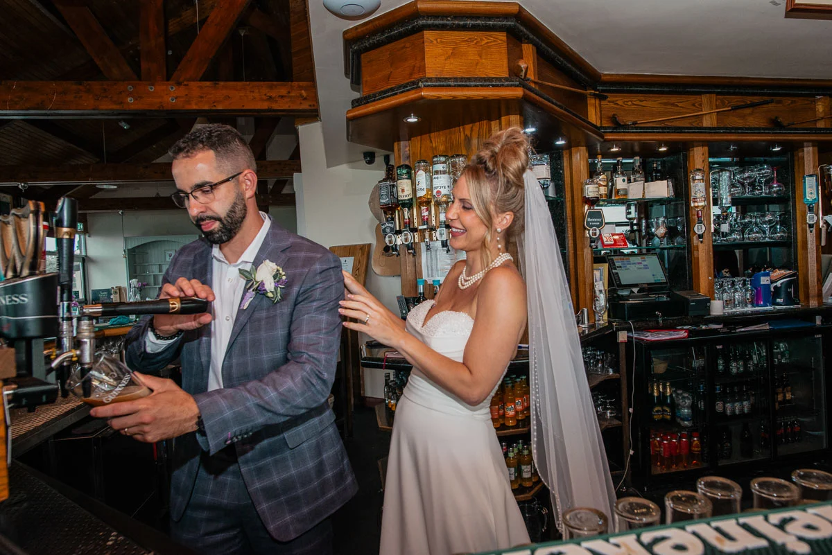 Bride and groom pulling Guinness pints after Ireland wedding celebration
