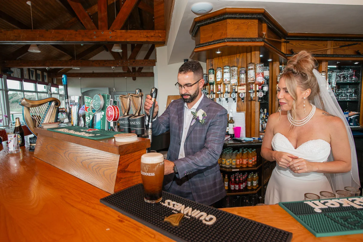 Newlyweds pouring Guinness in Irish pub after Black Castle wedding