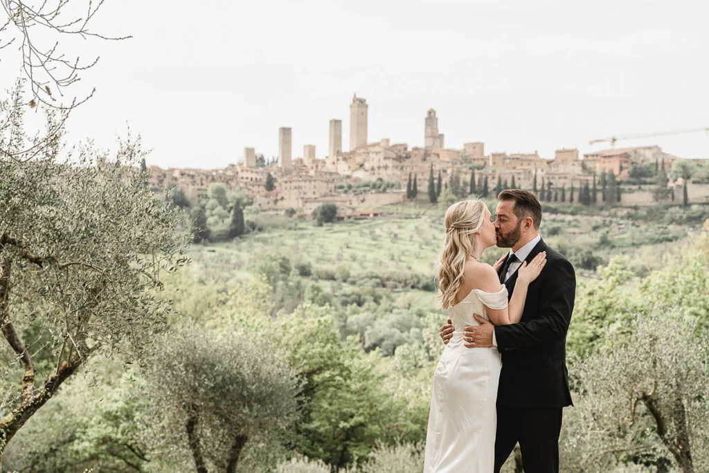 wedding in Tuscany-San Galgano-57 Couple kissing in front of San Gimignano medieval towers, Tuscany wedding