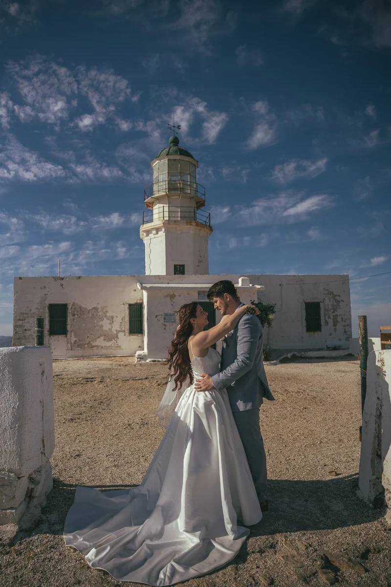 Devin and Daniel sharing an intimate moment in front of the Armenistis lighthouse in Mykonos