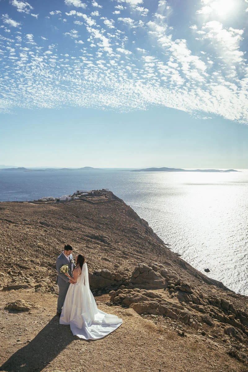 Devin and Daniel on the cliffs of Mykonos with the Aegean Sea stretching behind them