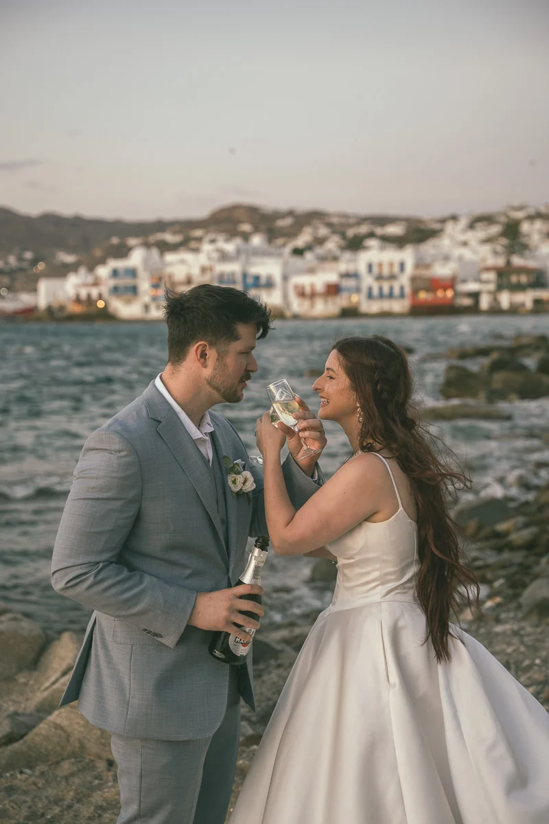 Devin and Daniel celebrating with champagne at Little Venice after their Mykonos elopement