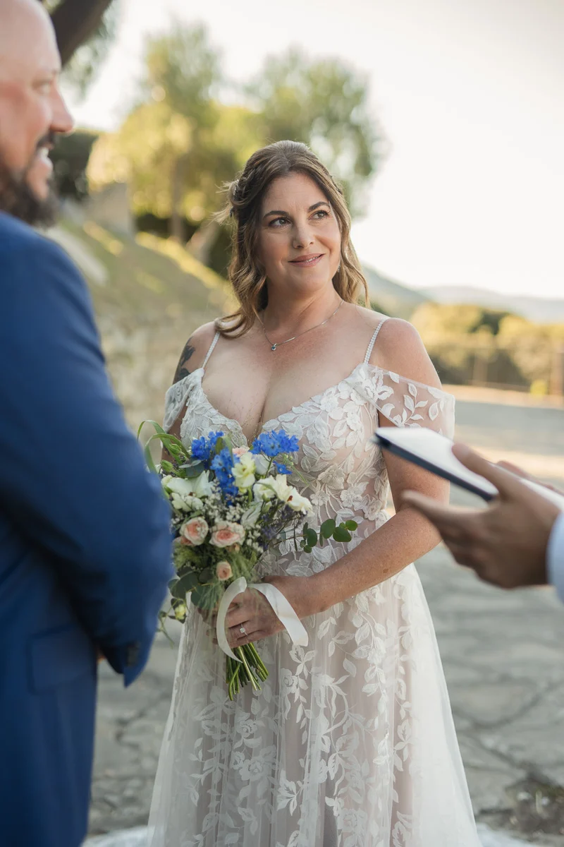 elopment at Fiesole, Tuscany-09 Bride with emotional smile holding wildflower bouquet during elopement vows in Fiesole, Tuscany, at golden hour
