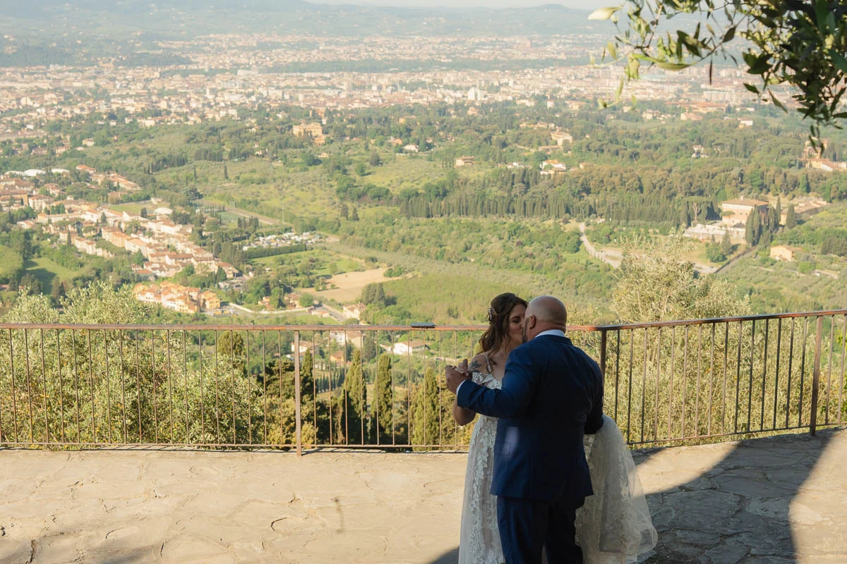 elopment at Fiesole, Tuscany-18 Newlyweds sharing their first kiss as a married couple on a hilltop terrace overlooking the Tuscan valley and Florence after their elopement