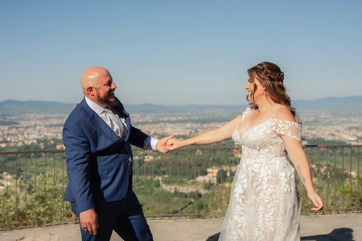 elopment at Fiesole, Tuscany-20 Just-married couple laughing and holding hands on a terrace overlooking Florence after their Fiesole elopement ceremony